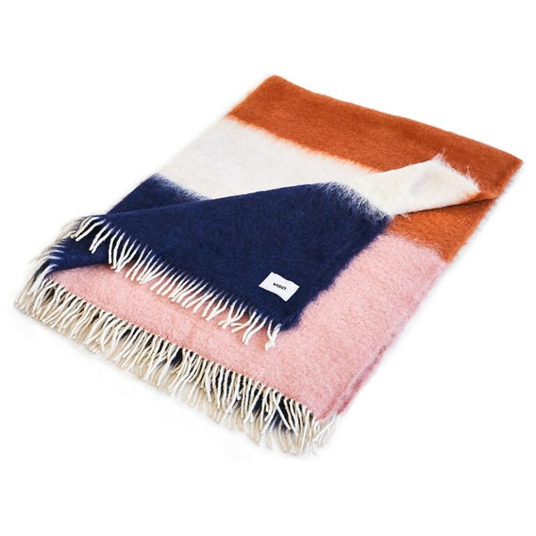 White, orange and navy mohair blanket resting on white background